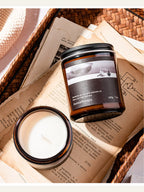 Candle and jar on an open book with a wicker basket background