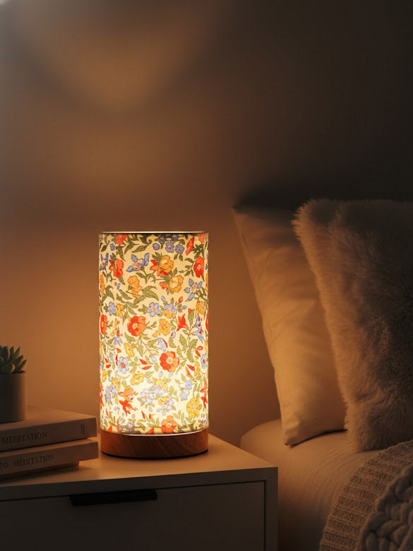 Floral-patterned lamp on a bedside table with a cozy bedroom setting.