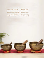 Three tibetan singing bowls of different sizes on a red mat with specifications displayed.