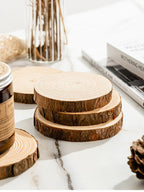 Wooden coasters stacked on a marble surface with a jar and book in the background.