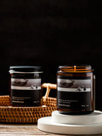 Two candles with labels on a dark background