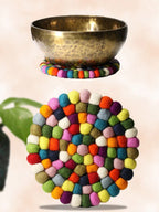 Colorful felt coaster with a brass bowl on a light background