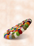 Colorful braided bracelet on a light pink background