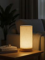 Lamp on a table with books and glasses in a dimly lit room