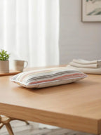 Striped pillow on a wooden table with a blurred background